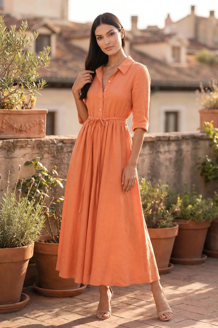 Model wearing orange tie waist midi dress in outdoor lifestyle setting