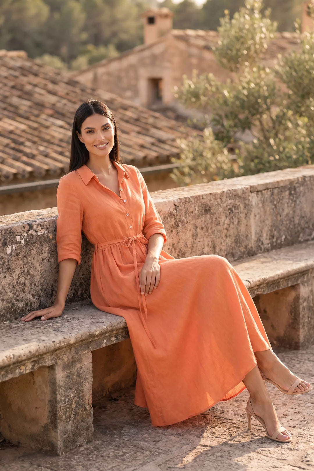 Model wearing orange tie waist midi dress in second outdoor lifestyle setting