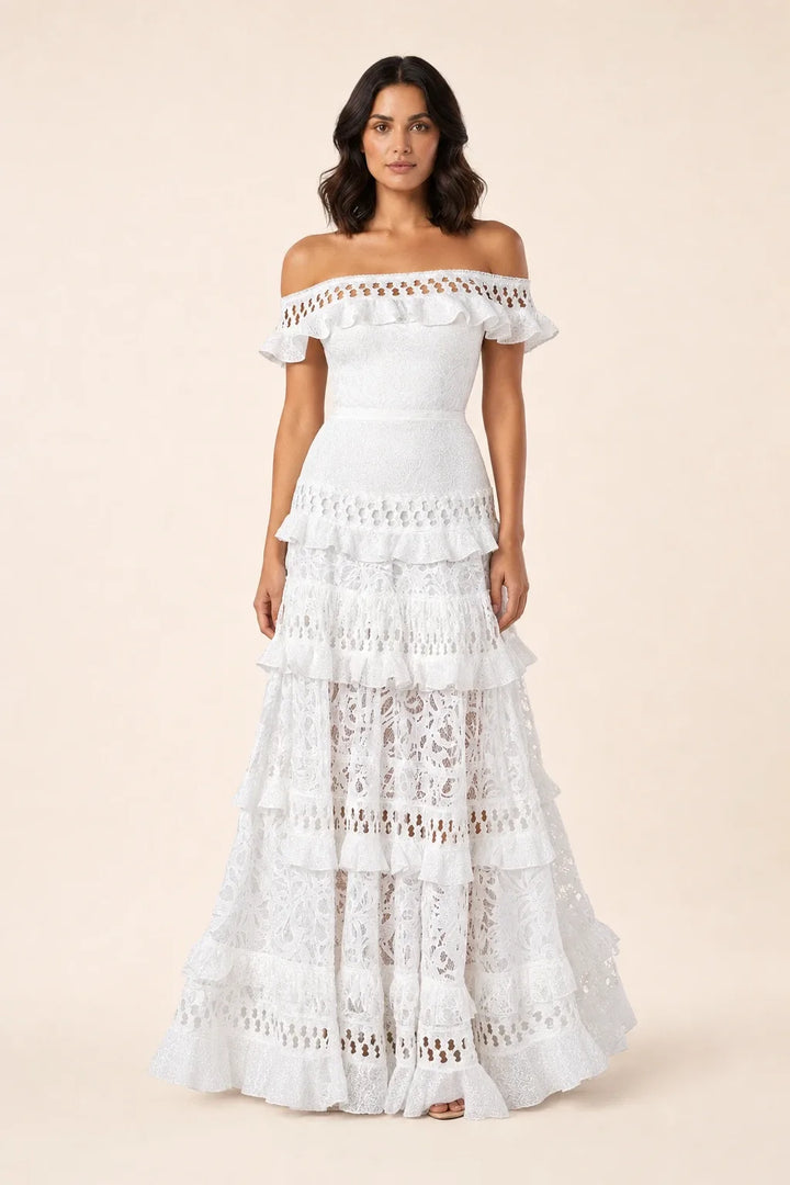 White tiered lace gown on model in contrapposto stance, floor-length silhouette with layered skirt