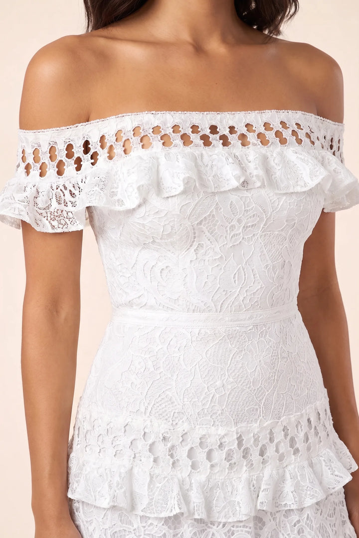 Close-up detail of white tiered lace gown fabric and layered hem construction