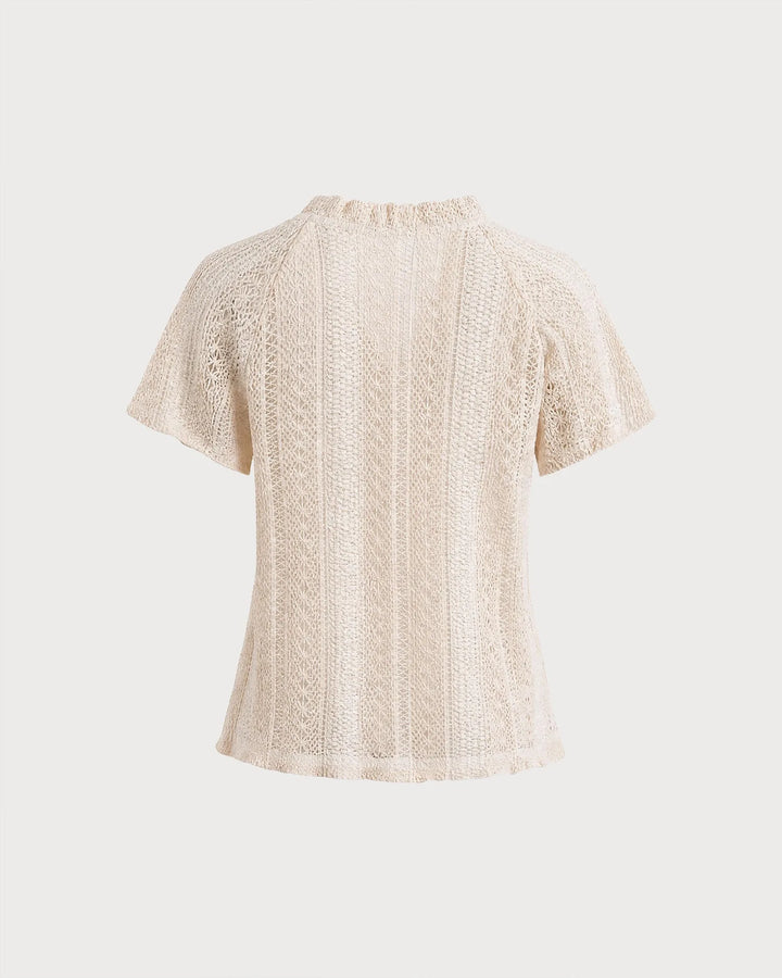 Side view of a woman in an apricot crochet blouse with a ruffled neckline