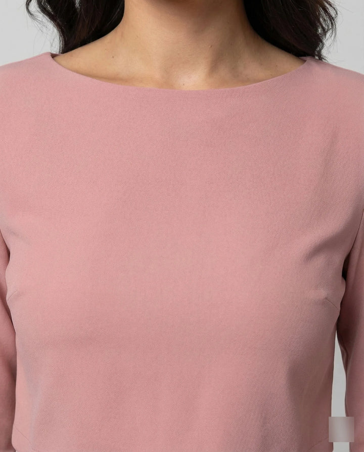 Woman in a pink wide-leg trouser set turned three-quarters to show silhouette