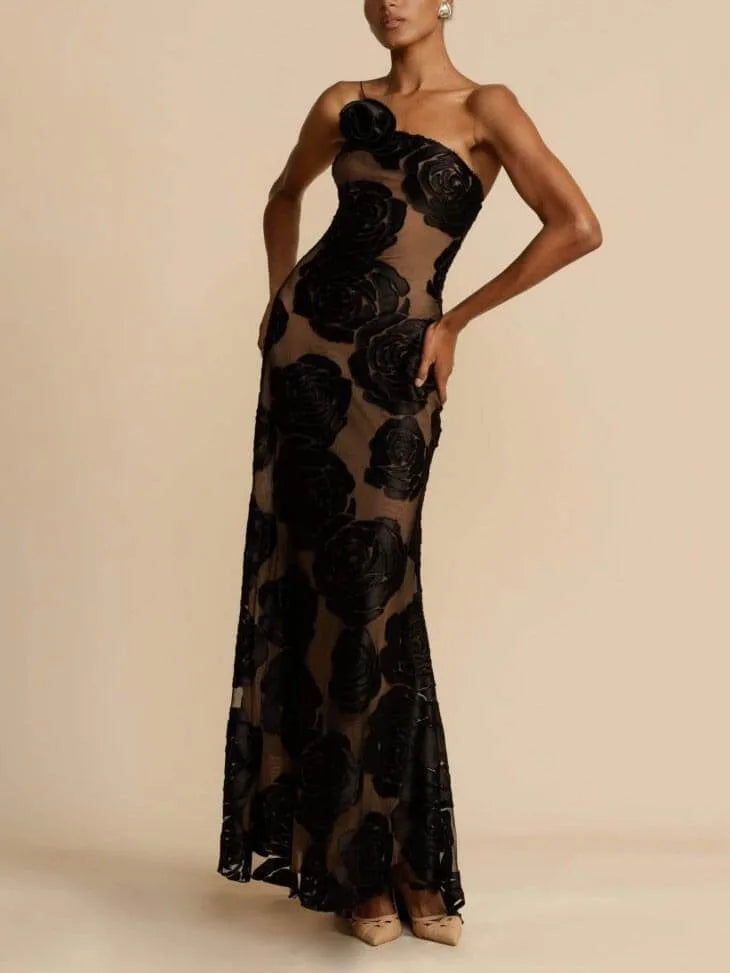 Model in a three-quarter turn wearing a black floor-length gown with rose appliqués