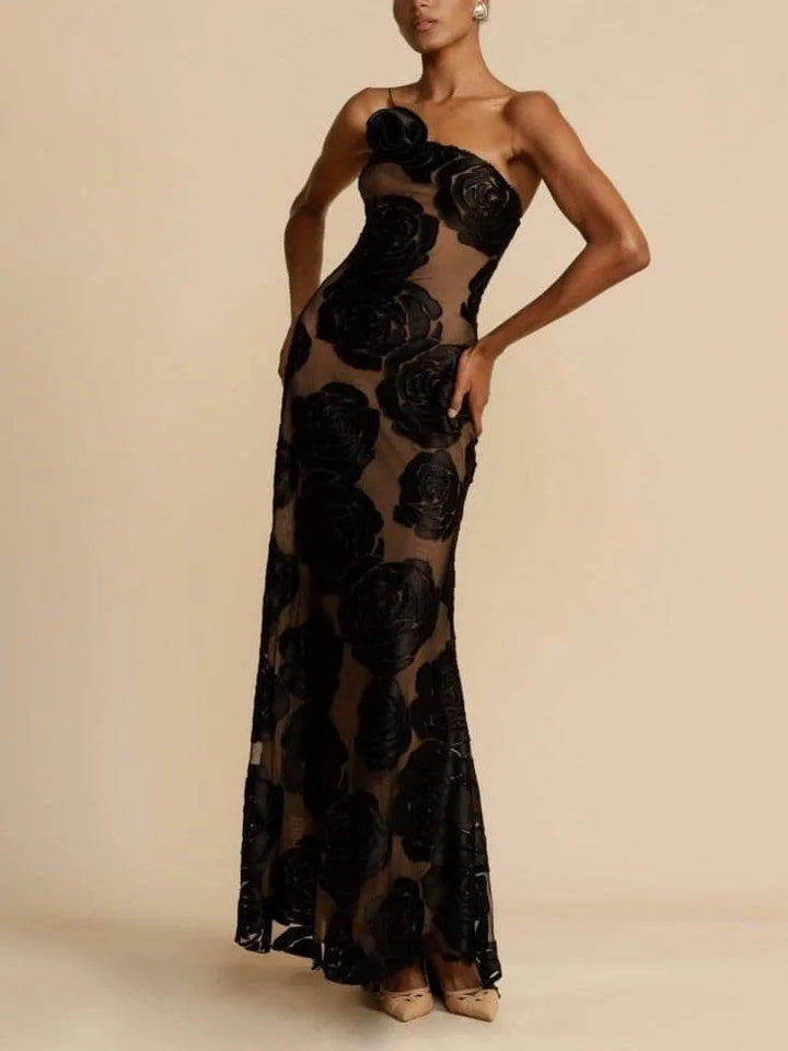 Model in a three-quarter turn wearing a black floor-length gown with rose appliqués