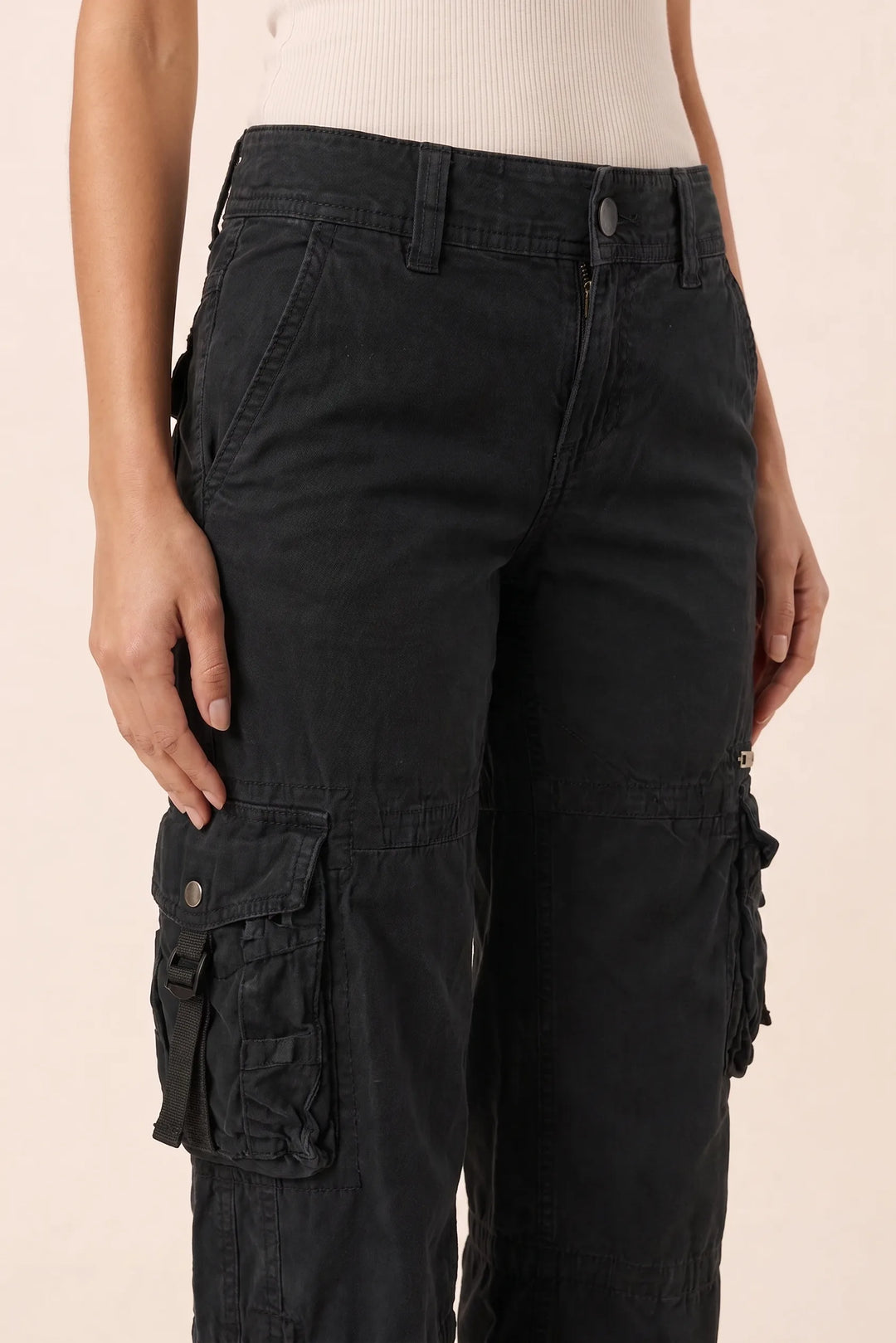 Close-up detail of black wide-leg cargo pants showing fabric and pockets