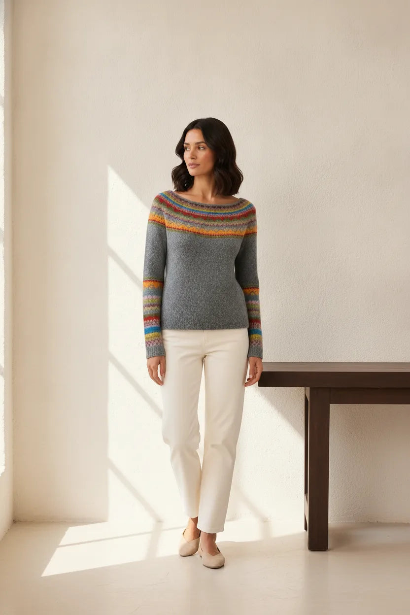 Colorblock stripe sweater in gray and rainbow tones, model posed outside a storefront