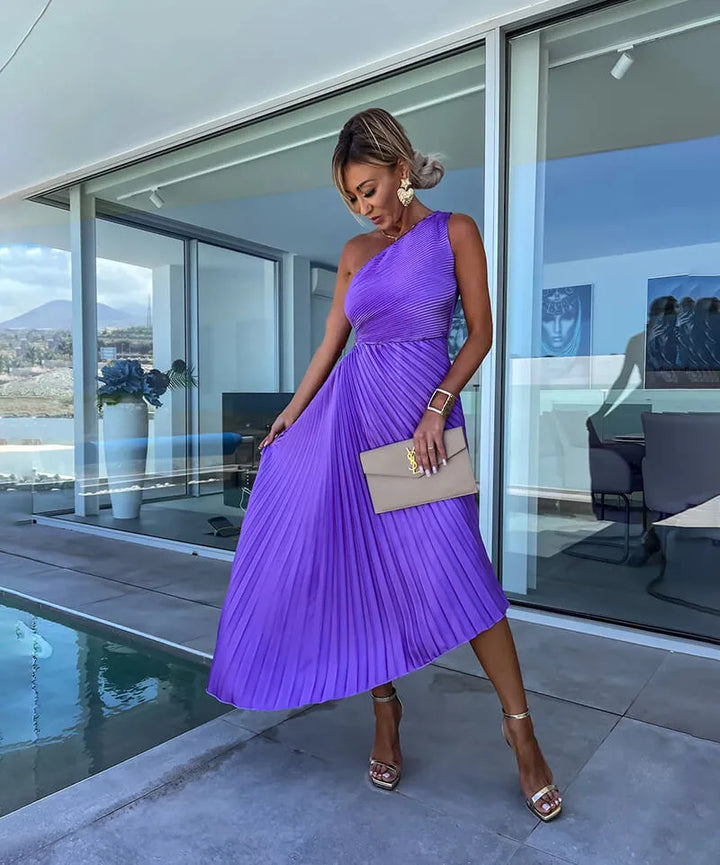 Close-up detail of purple pleated one-shoulder midi dress fabric and neckline