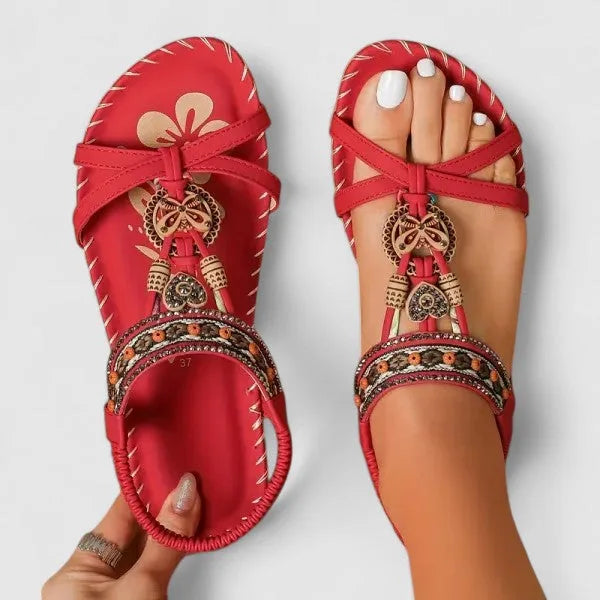 Red beaded flat sandal with woven boho straps, side profile view