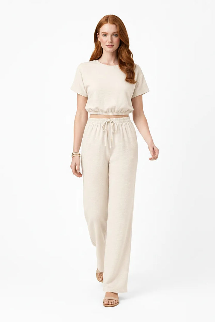 Beige crop top and wide-leg trouser co-ord set on model in natural movement