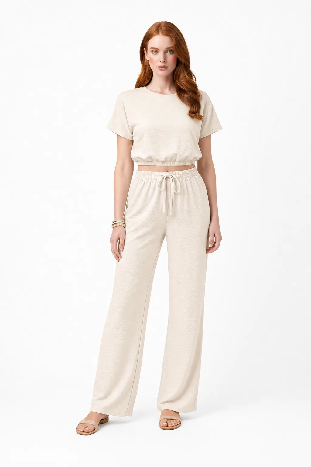 Beige crop top and wide-leg trouser co-ord set on model in contrapposto stance