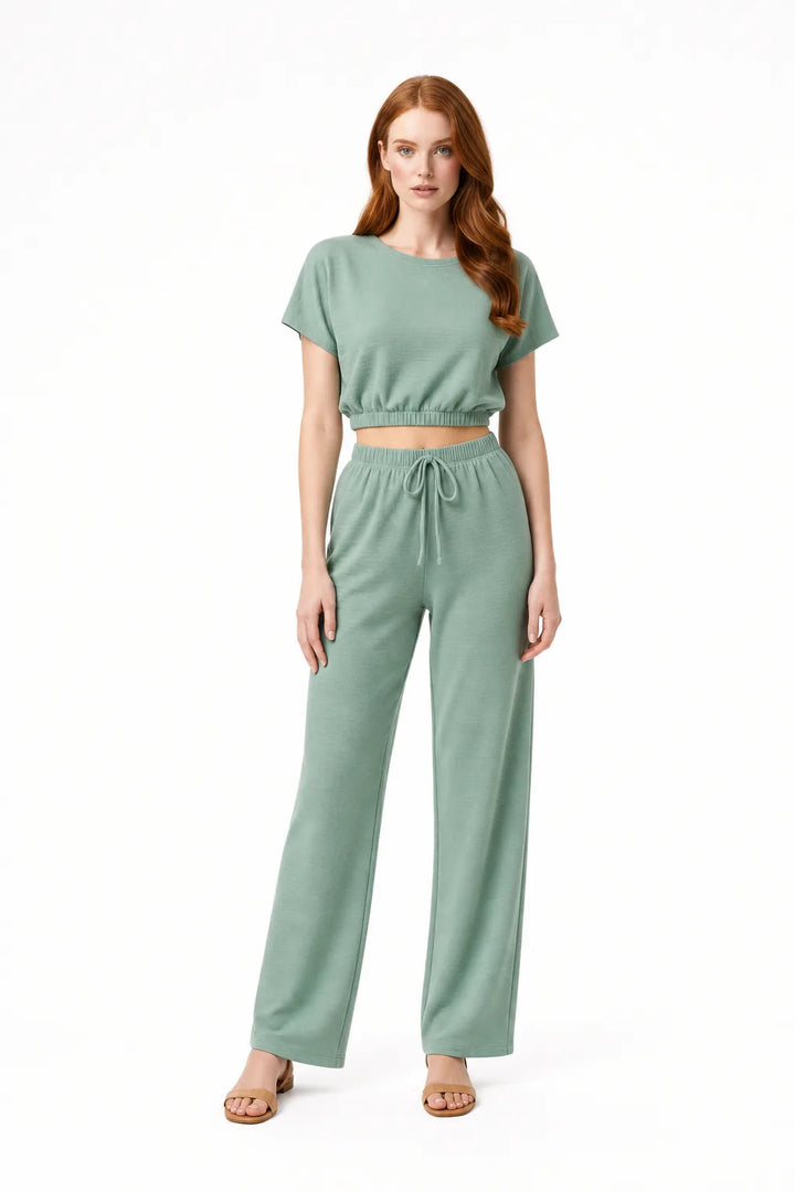 Lime green crop top and wide-leg trouser co-ord set on model in contrapposto stance
