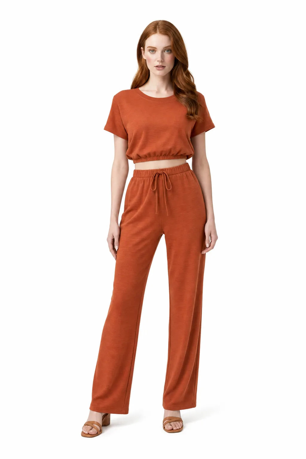Orange-red crop top and wide-leg trouser co-ord set on model in contrapposto stance