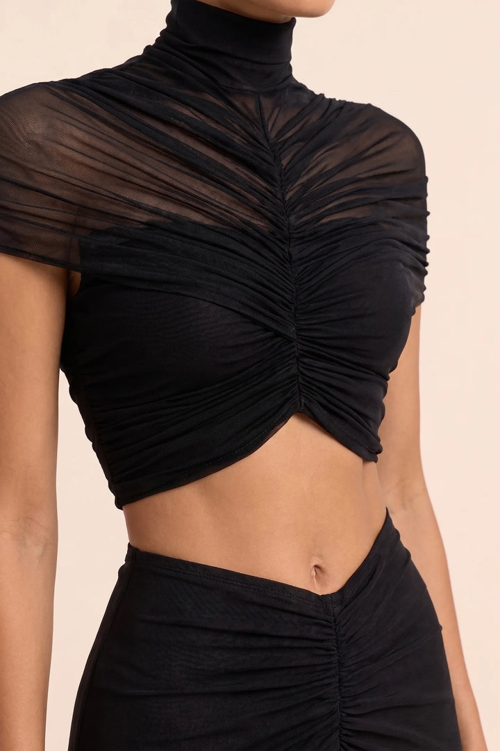 Close-up detail of ruching and cut-out on black maxi dress