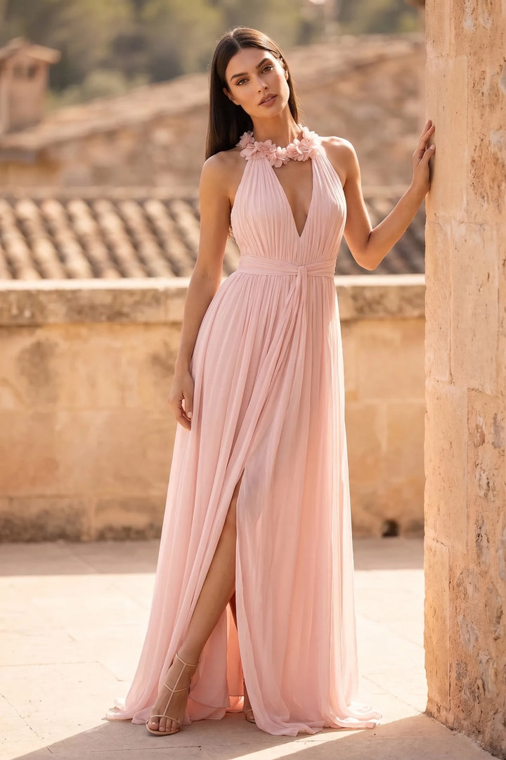 Model wearing pink floral halter maxi dress in outdoor lifestyle setting