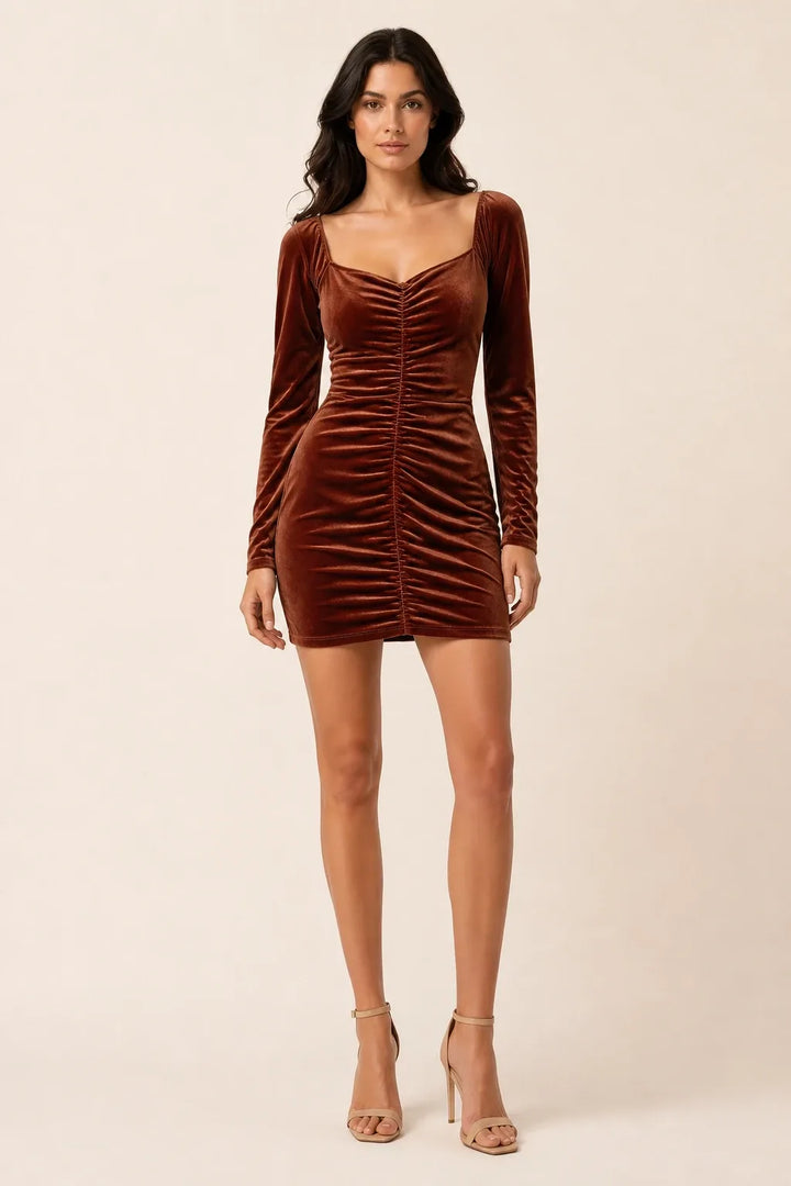 Brown ruched velvet mini dress on a model in contrapposto stance