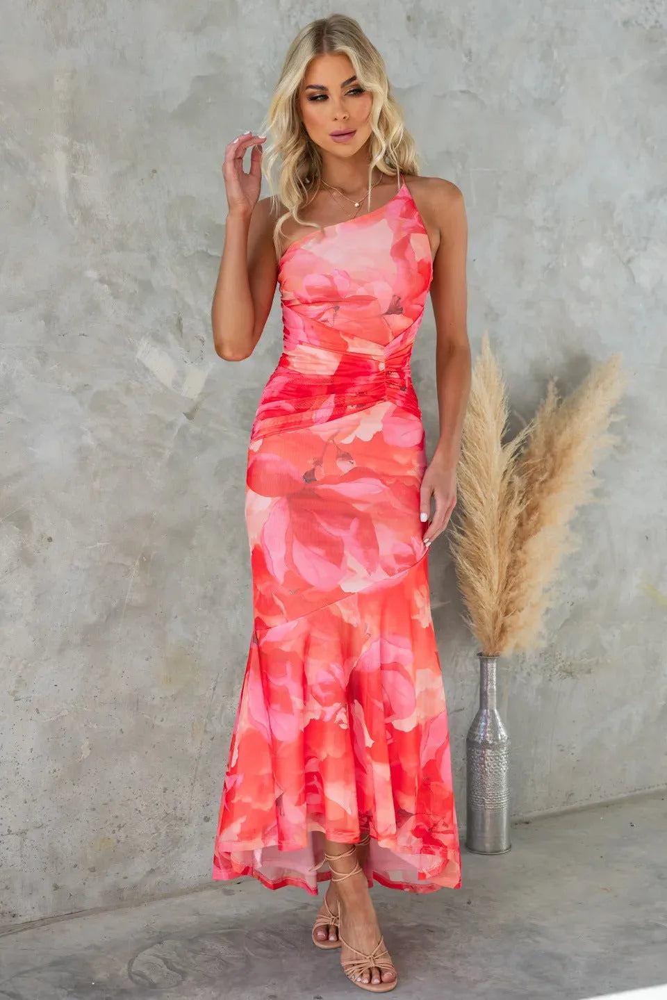 Side view of a woman in a blue floral ruched maxi dress showing silhouette and length