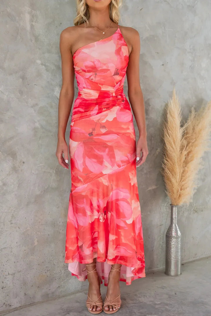 Woman posing in a red floral ruched maxi dress with gathered detailing