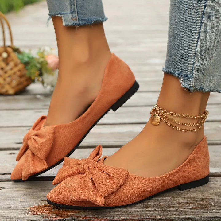 Orange ballet flat with bow detail, side profile view