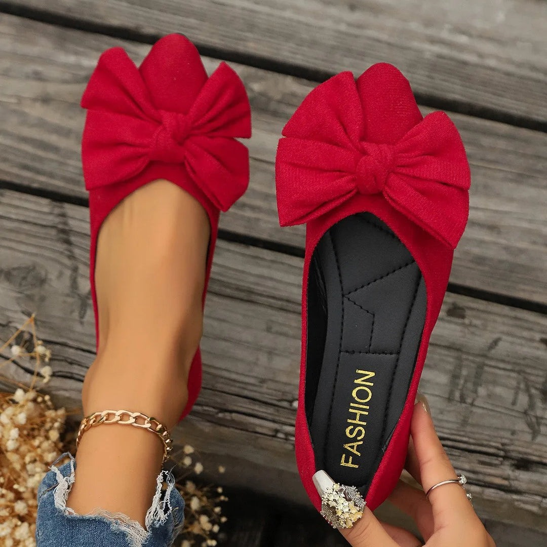 Red ballet flat with bow detail, three-quarter angle view