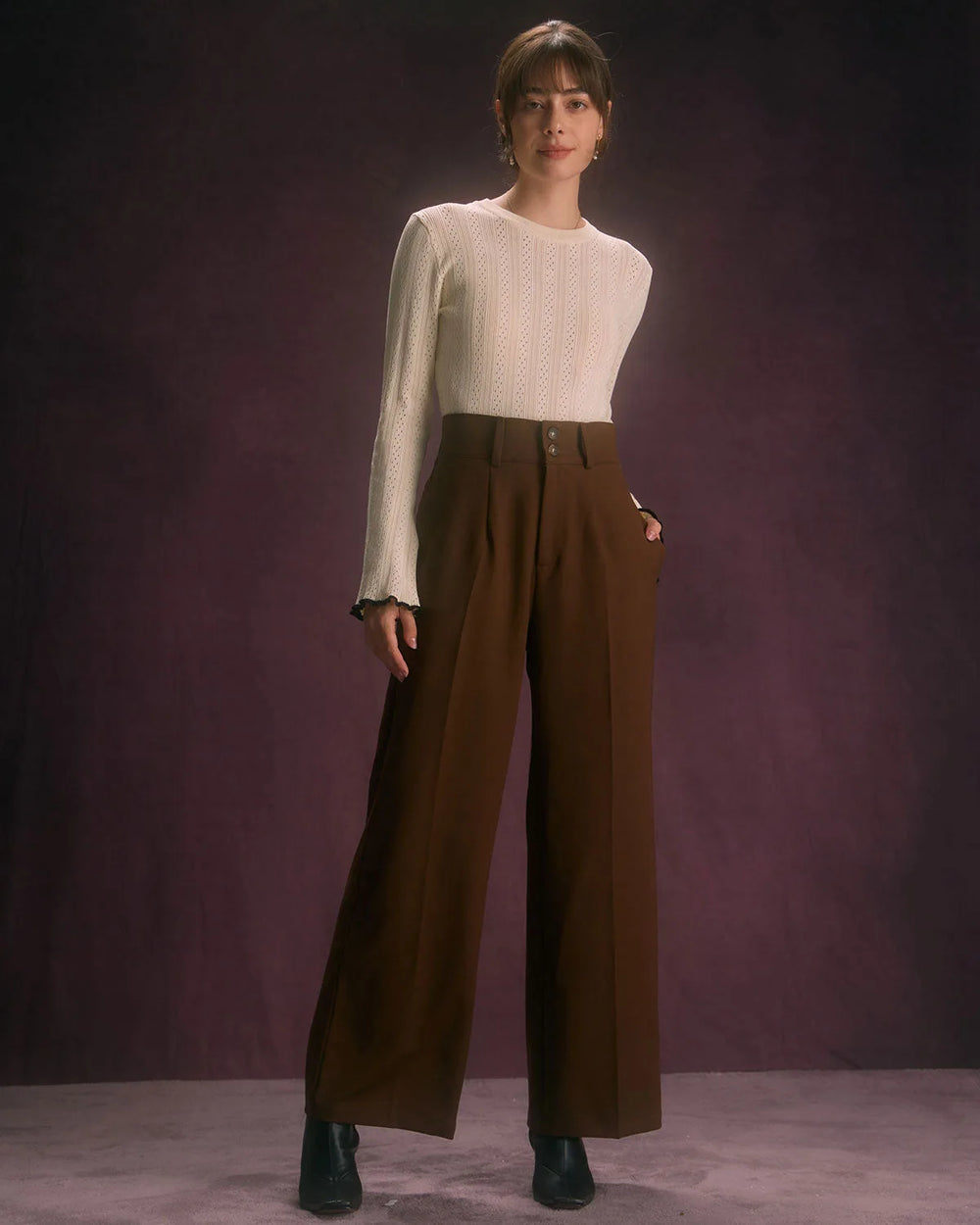 Close-up detail of wide-leg coffee brown trousers showing fabric texture and waistband finish