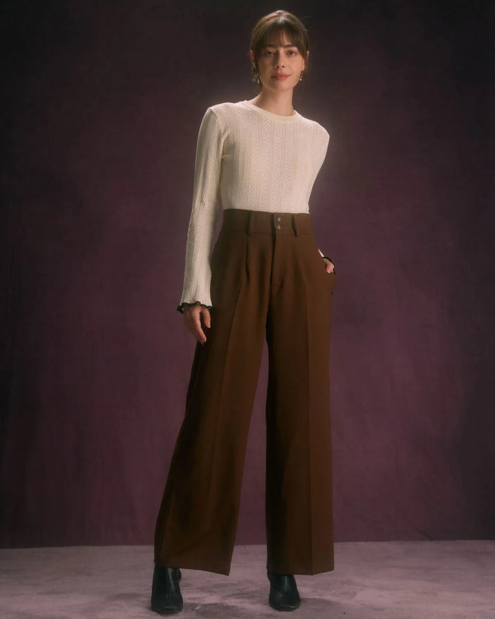 Close-up detail of wide-leg coffee brown trousers showing fabric texture and waistband finish