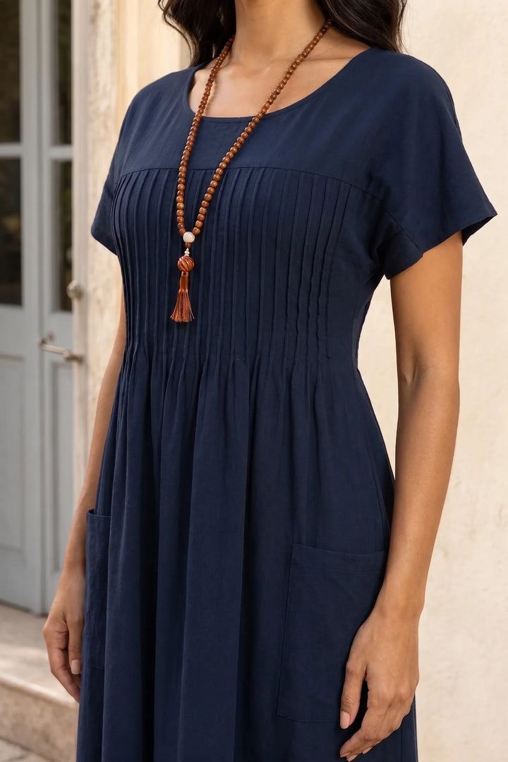 Close-up detail of blue pintuck midi dress showing vertical pleat texture and fabric