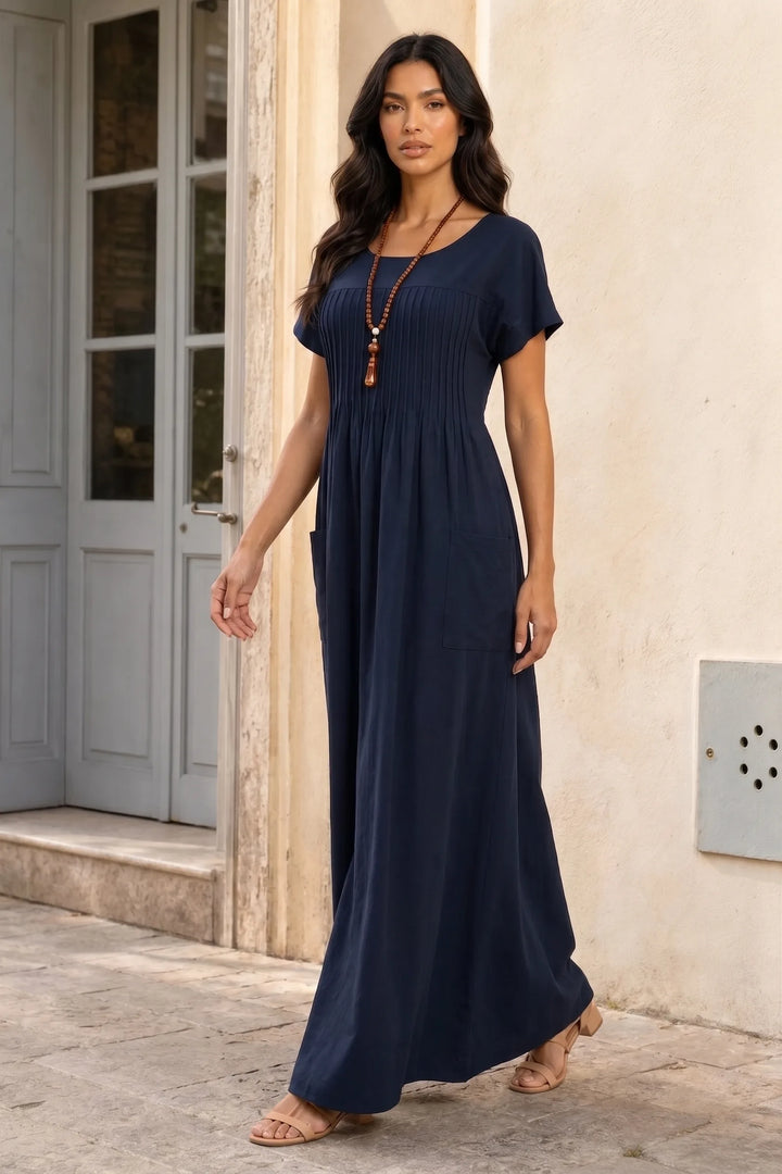 Blue pintuck midi dress on model in three-quarter turn, showing back and side silhouette
