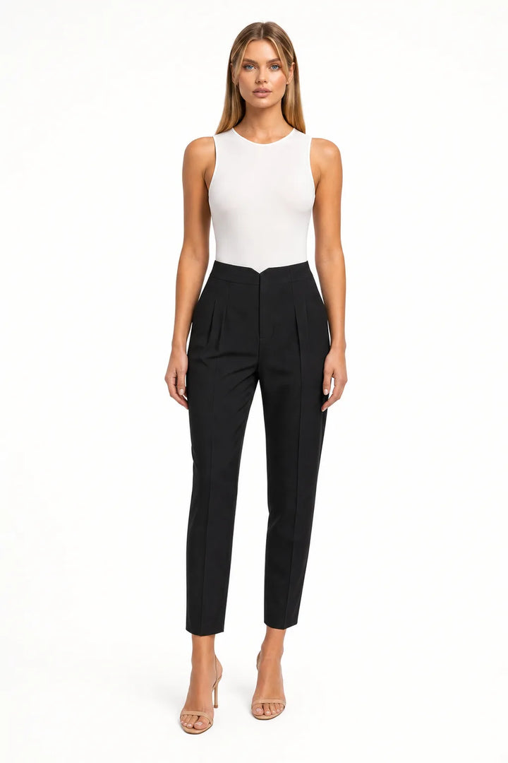 Black pleated tapered trousers on a model in a contrapposto stance