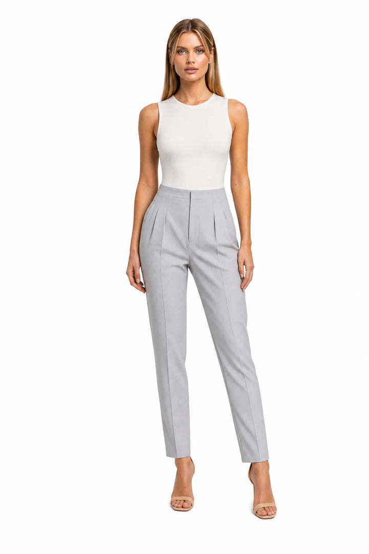 Grey pleated tapered trousers on a model in a contrapposto stance