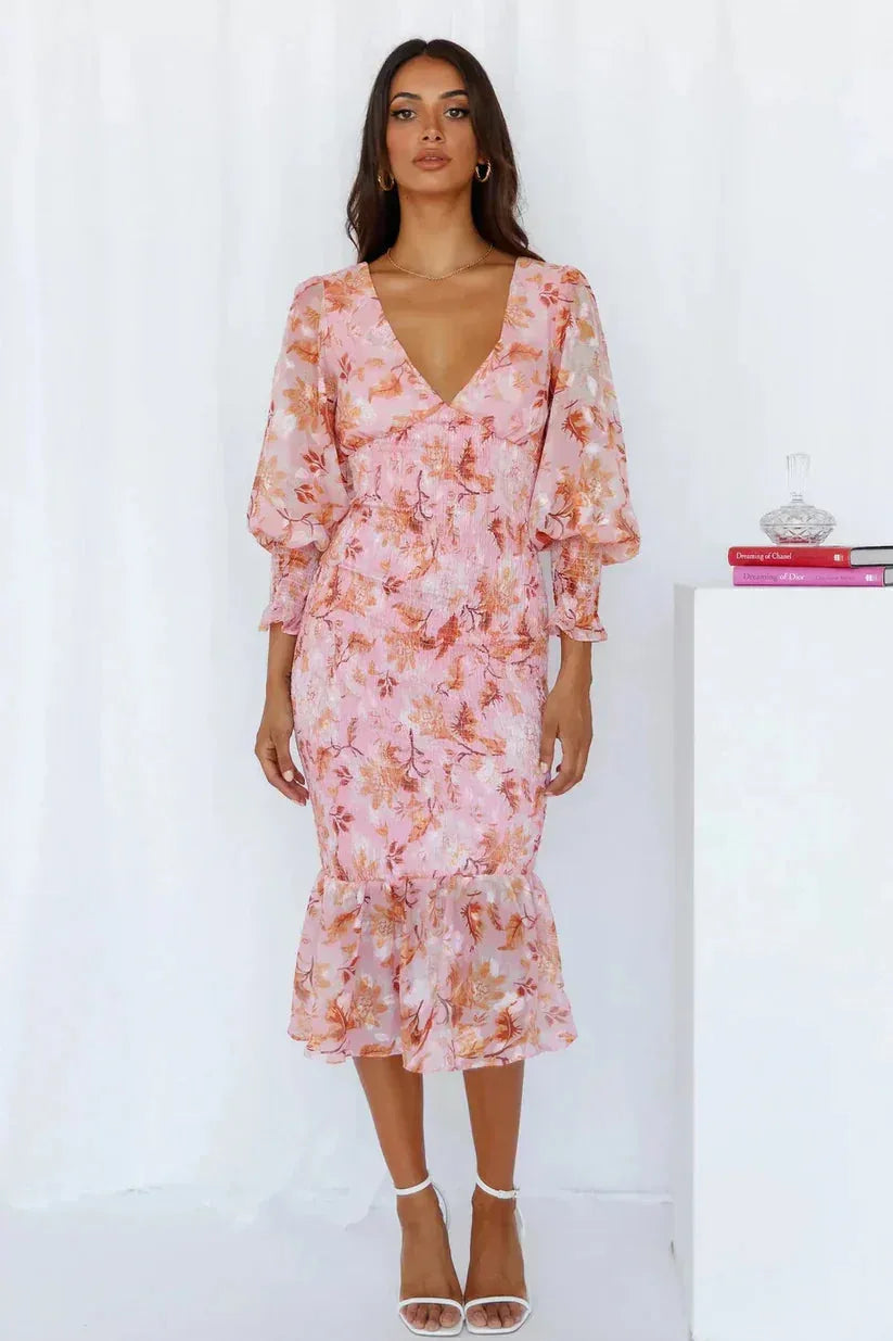 Close-up detail of pink floral fabric and ruching on a fitted mermaid midi dress