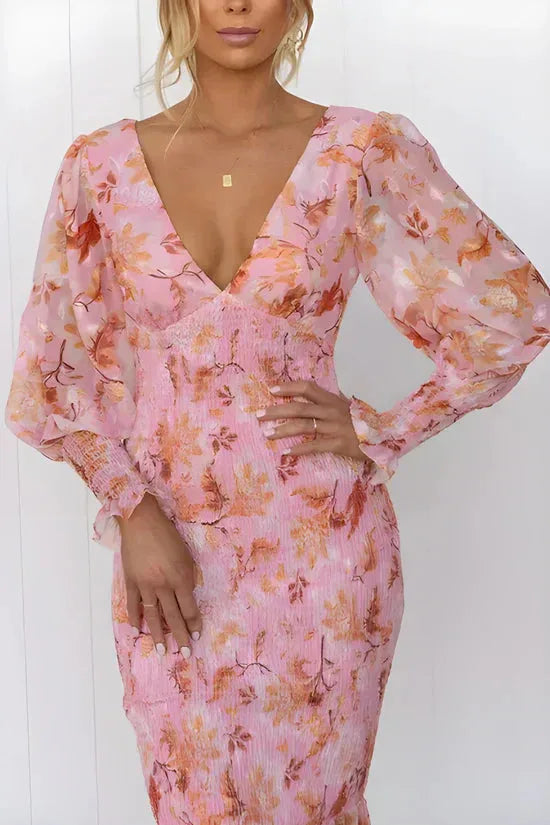 Side view of woman in a pink floral mermaid midi dress highlighting the flared silhouette