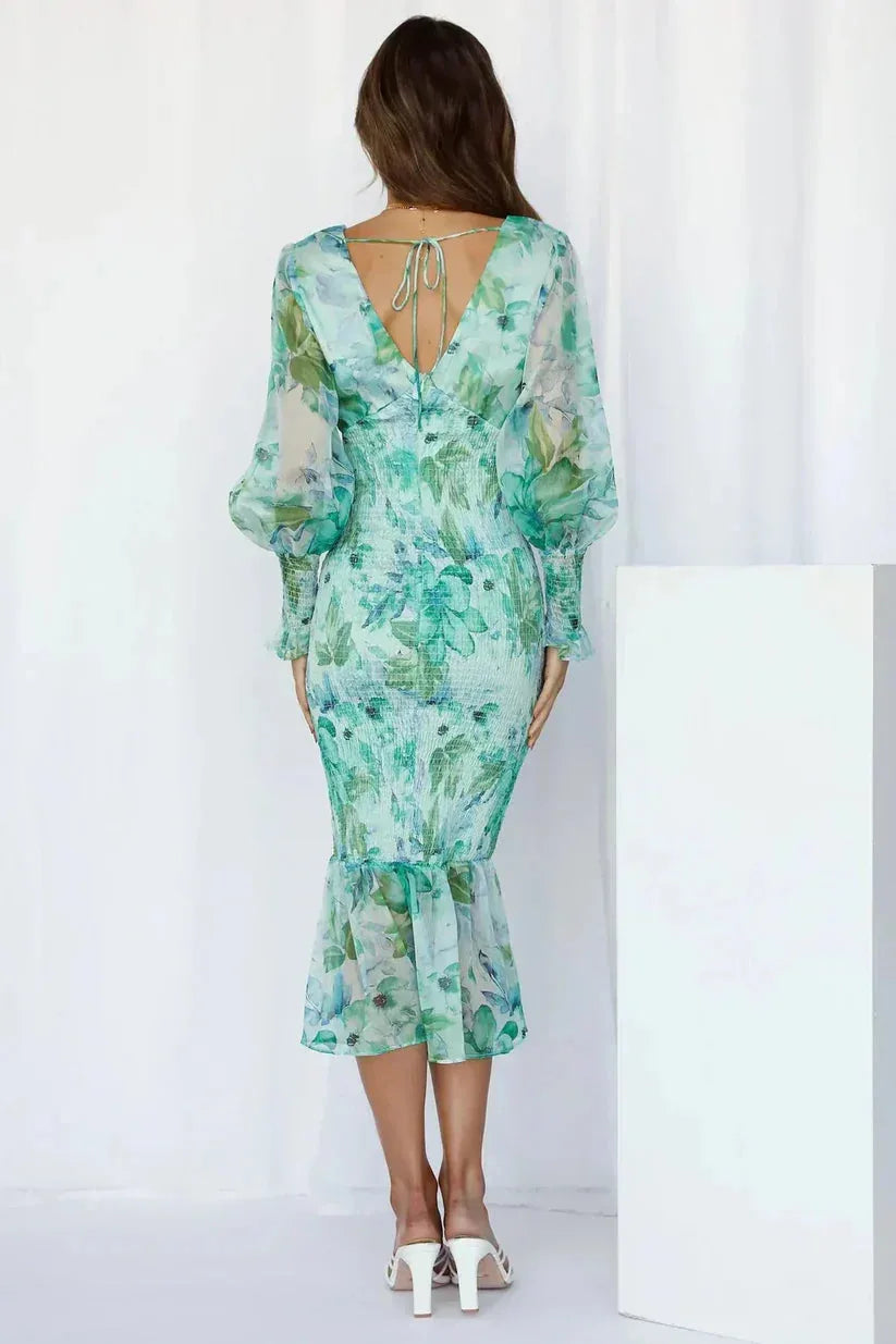 Woman in a pink floral mermaid midi dress showing full-length silhouette and floral print