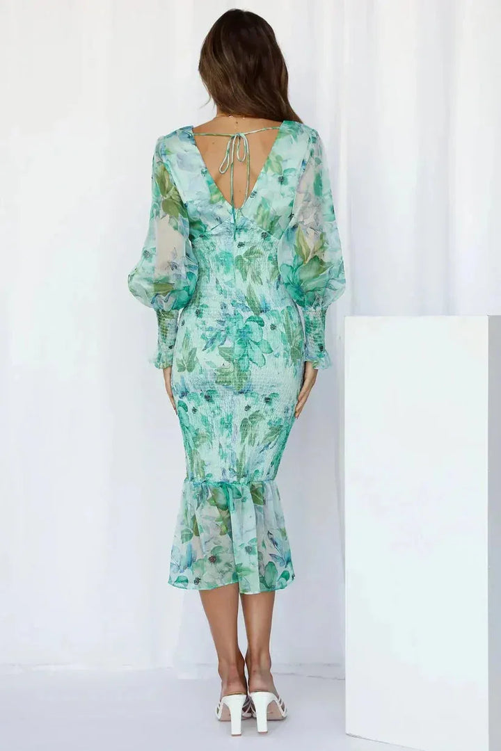 Woman in a pink floral mermaid midi dress showing full-length silhouette and floral print