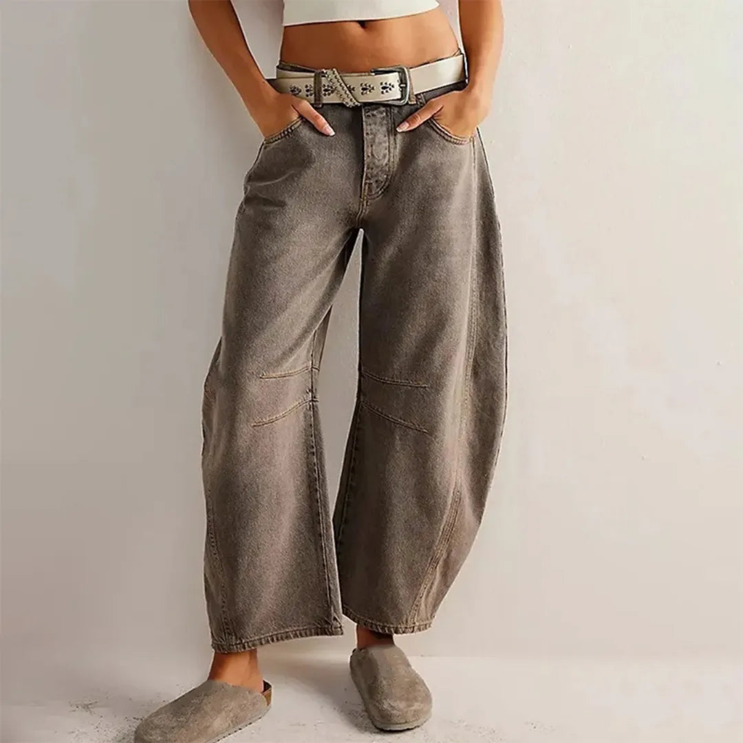 Dark gray barrel leg jeans on model, side view showing tapered silhouette