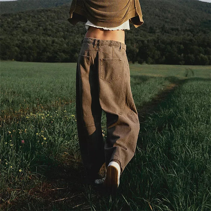 Light blue barrel leg jeans on model, full-length view emphasizing tapered fit
