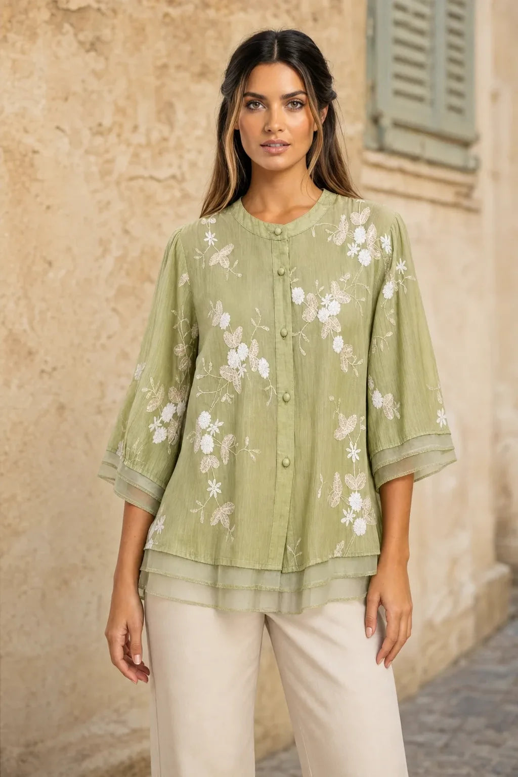Green embroidered mesh overlay blouse on model in contrapposto stance