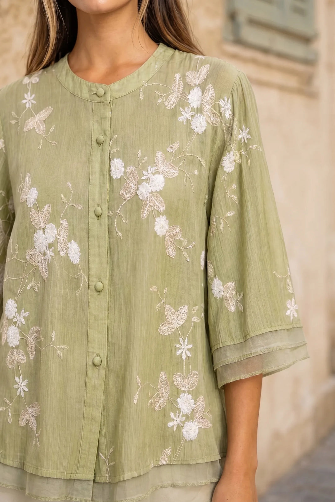 Close-up detail of green embroidered mesh overlay blouse