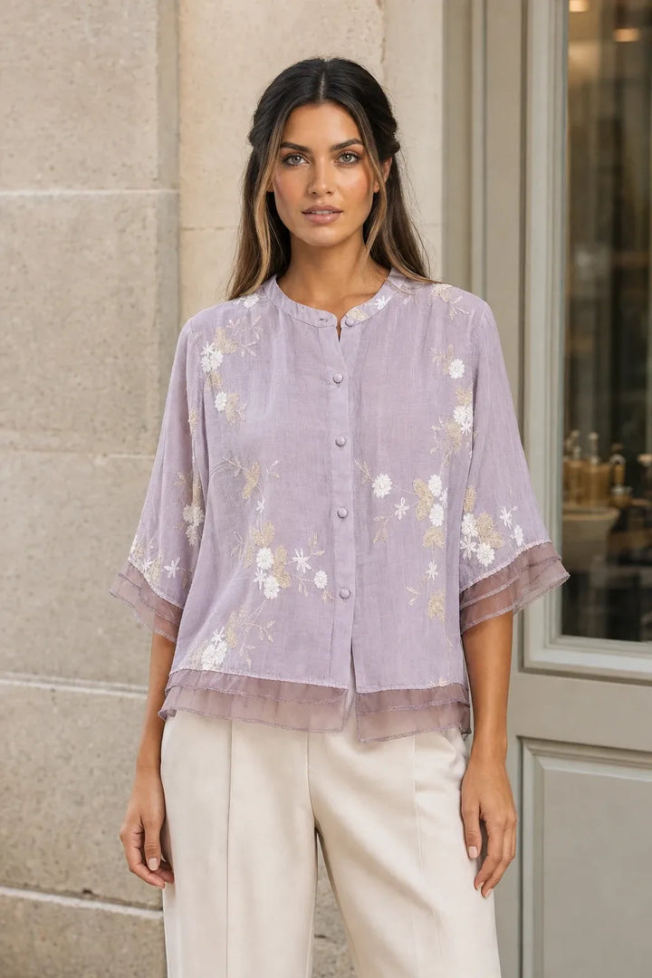 Purple embroidered mesh overlay blouse on model in contrapposto stance