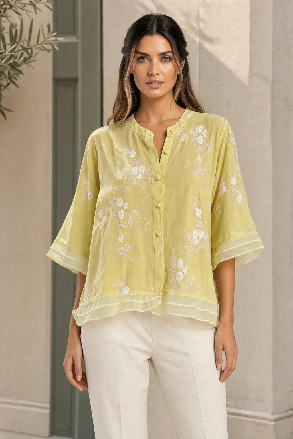 Yellow embroidered mesh overlay blouse on model in contrapposto stance