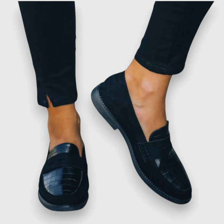 Side profile of a croc panel penny loafer showing textured detailing
