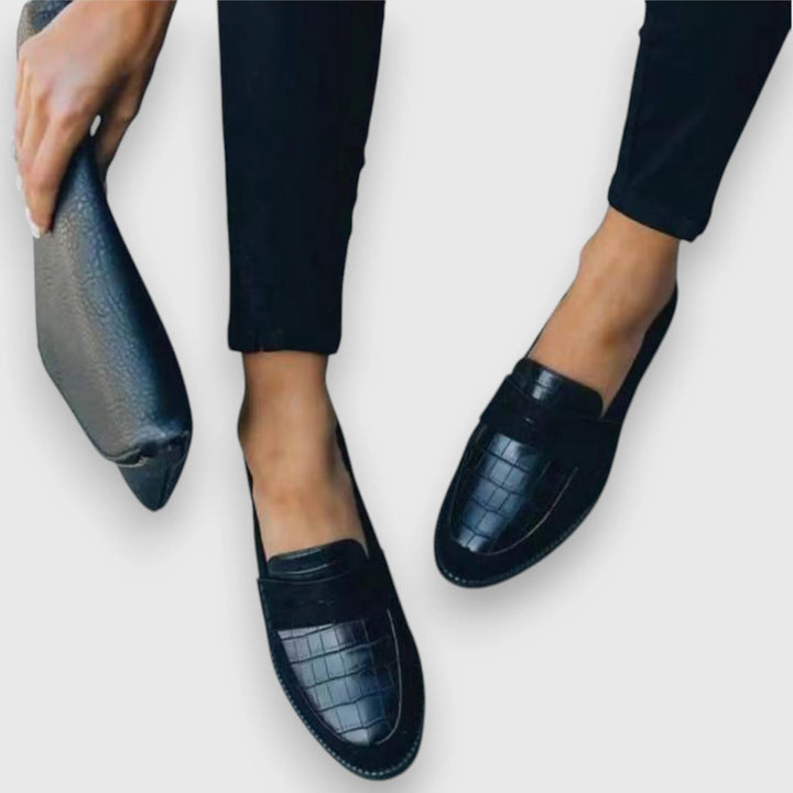 Three-quarter view of a croc panel penny loafer highlighting texture and silhouette