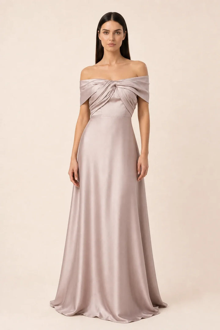 Woman in khaki off-shoulder satin gown, weight shifted to one hip in contrapposto stance