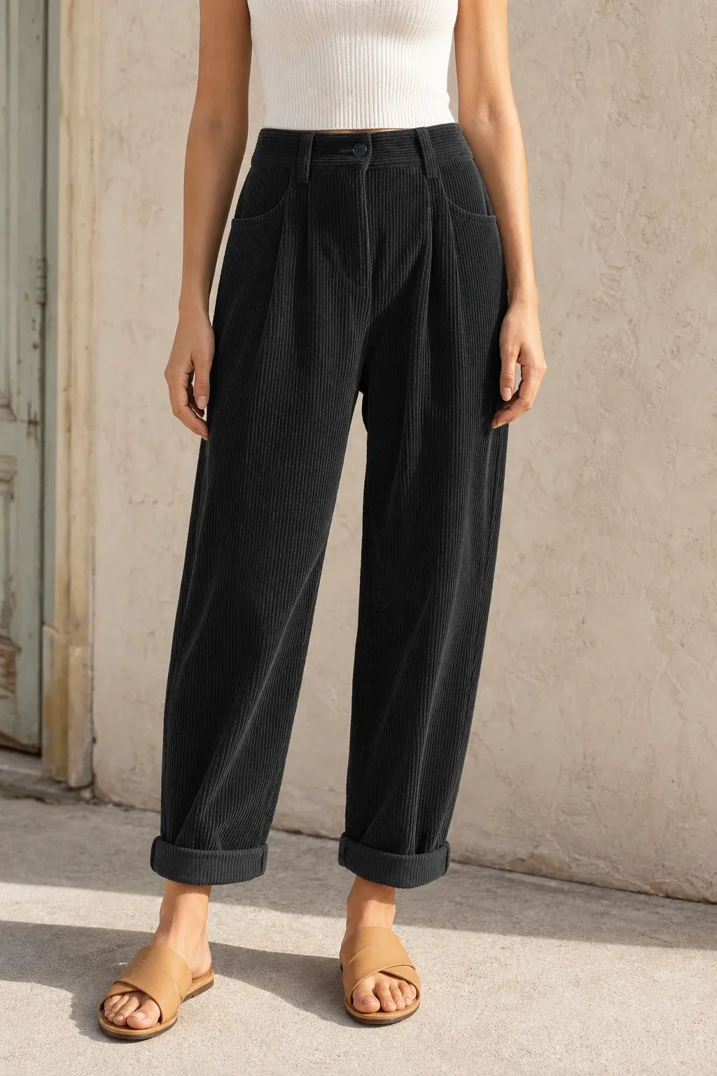 Black pleated corduroy pants on a model in a contrapposto stance