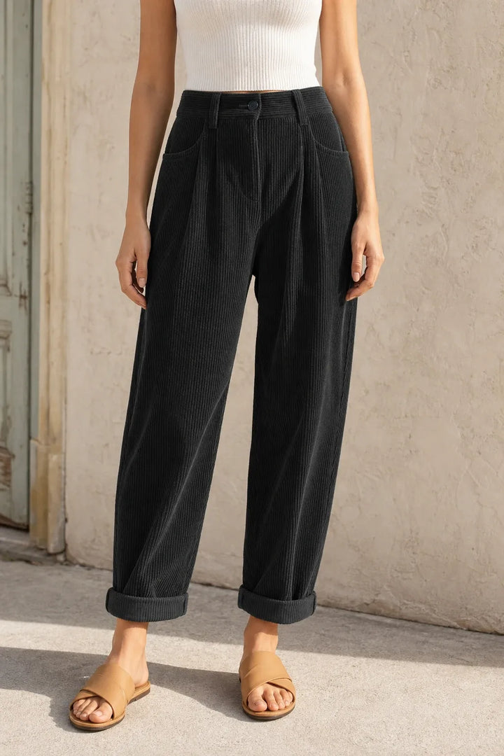 Black pleated corduroy pants on a model in a contrapposto stance
