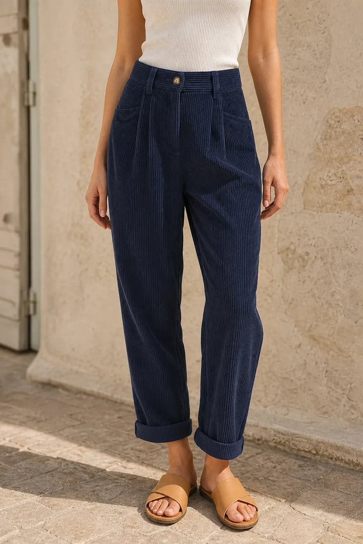 Blue pleated corduroy pants on a model in a contrapposto stance