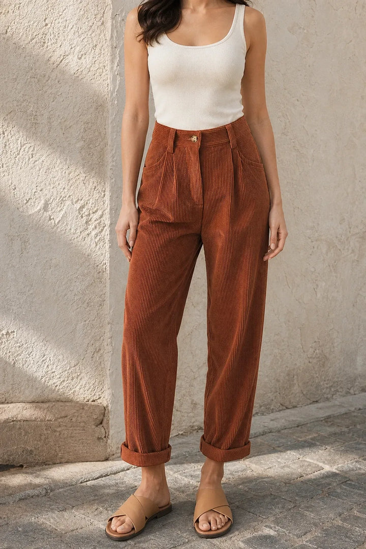 Brown pleated corduroy pants on a model in a contrapposto stance