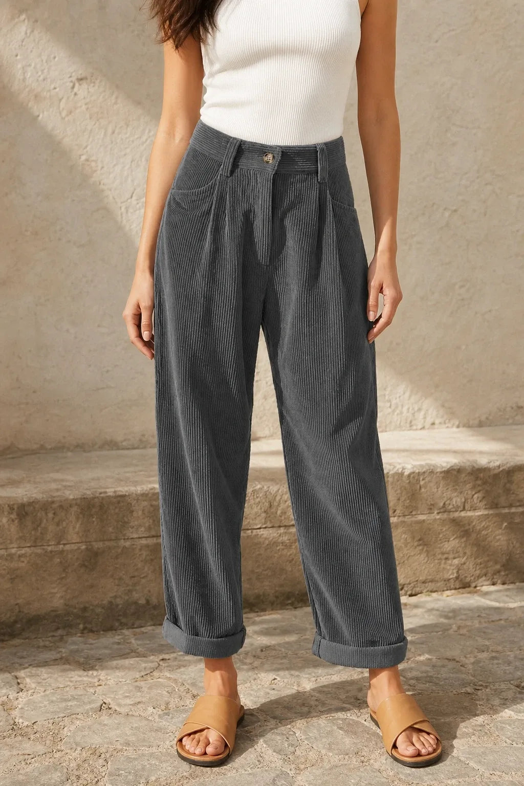 Gray pleated corduroy pants on a model in a contrapposto stance