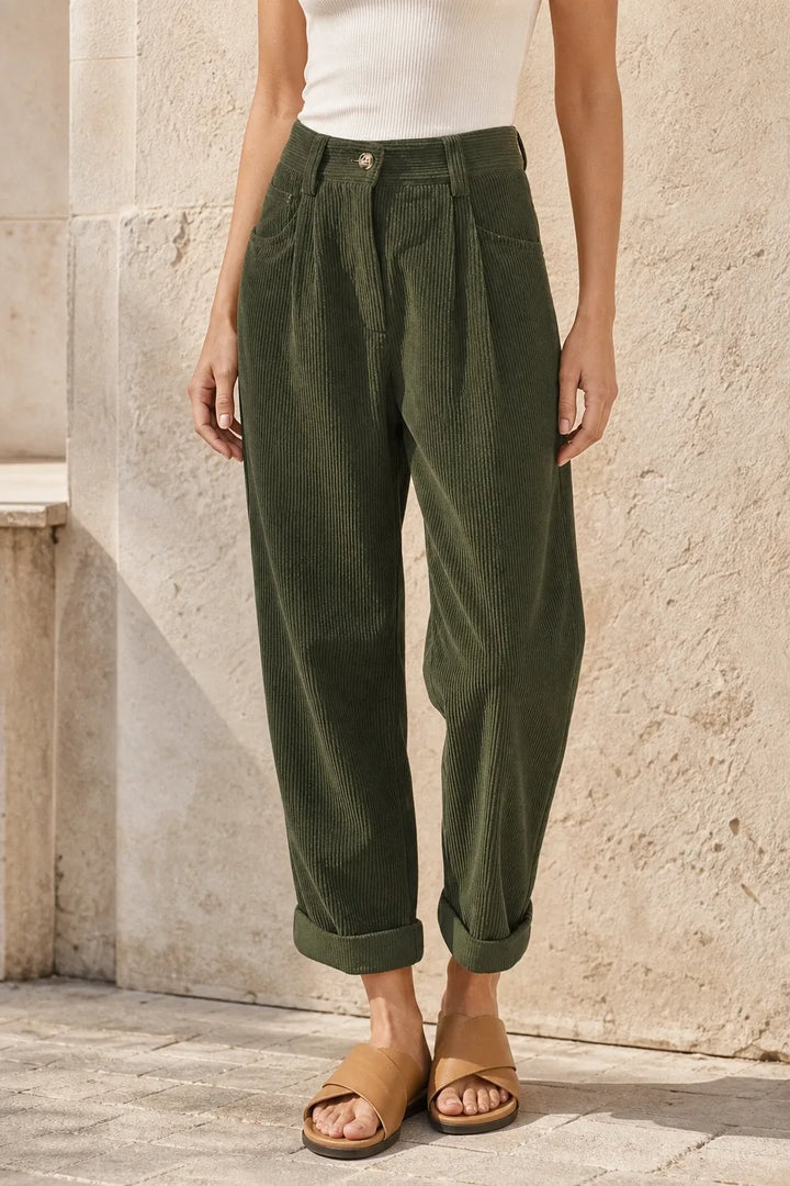 Green pleated corduroy pants on a model in a contrapposto stance