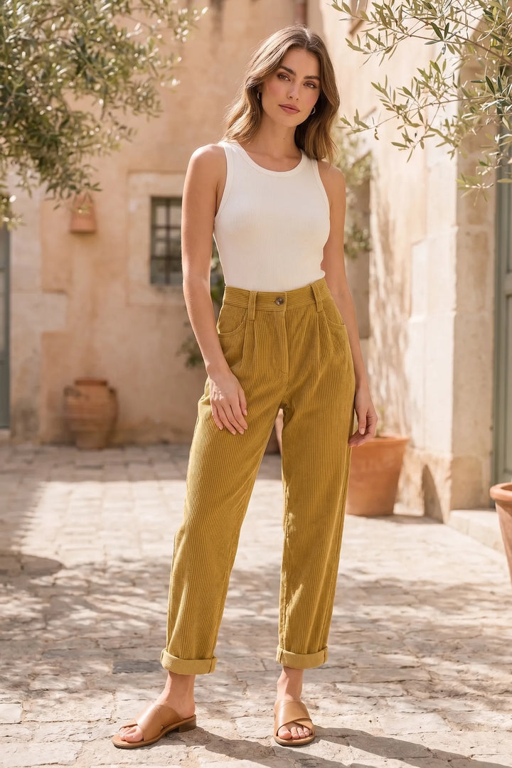 Model wearing yellow pleated corduroy pants in a lifestyle setting