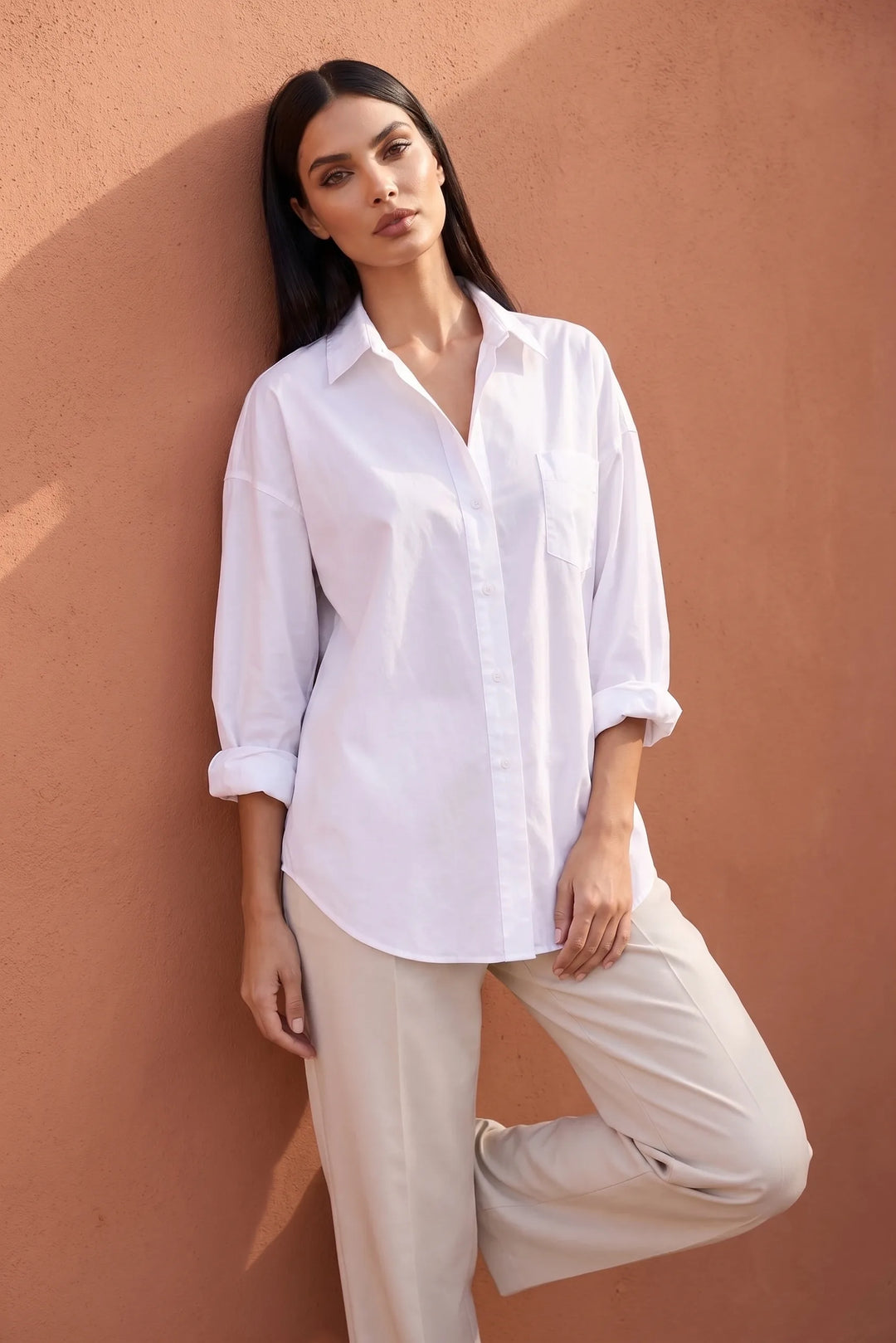 Model wearing white oversized button-down shirt in lifestyle setting